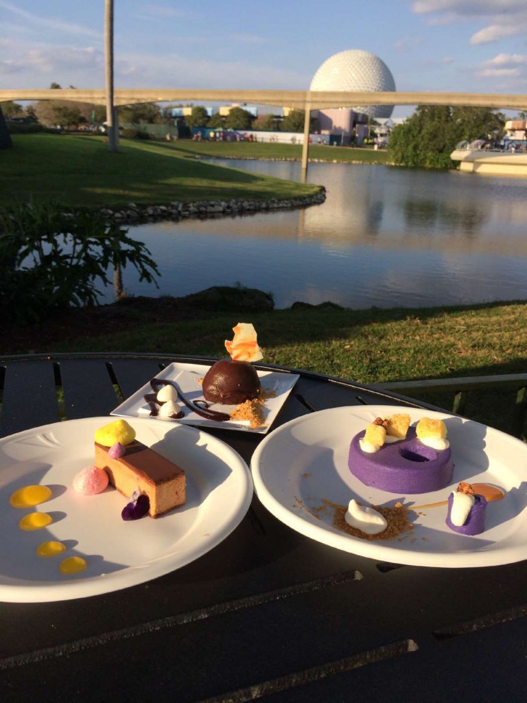 plates of gourmet food overlooking view at Epcot