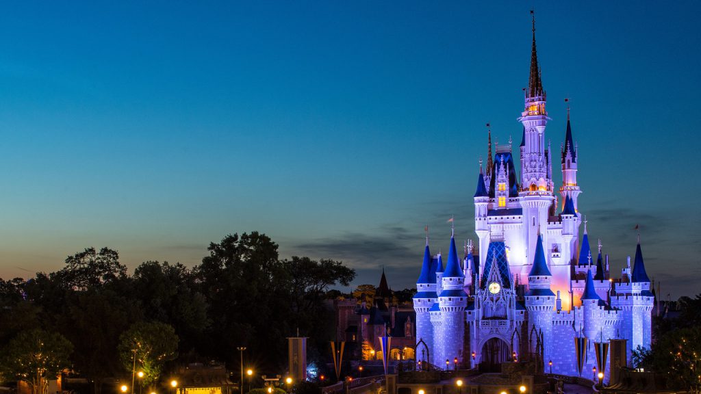 Disney castle lit up against night sky
