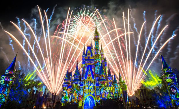 Disney castle lit up at night with fireworks show