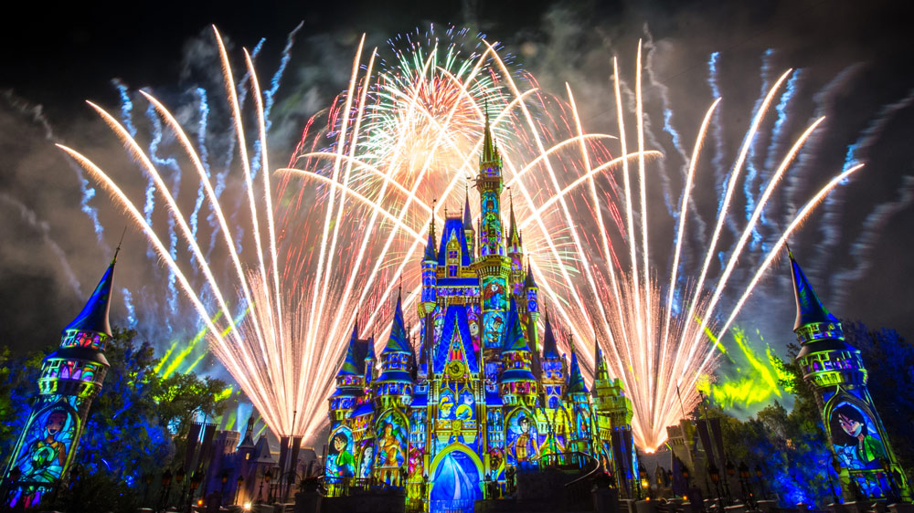 Disney castle lit up at night with fireworks show