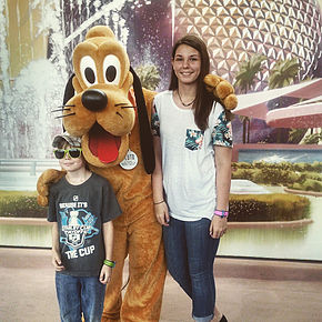boy and girl posing with Goofy at Epcot