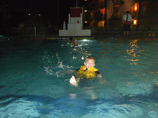 children happily swimming in pool