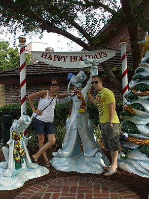 couple posing by Happy Holidays Goofy statue