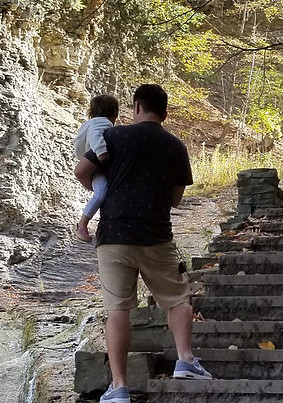 dad carrying baby up stone steps