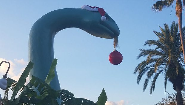 dinosaur holding Christmas ball ornament