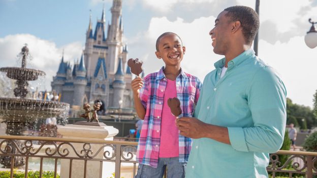 Father and son eating Mickey popsicles at Disney