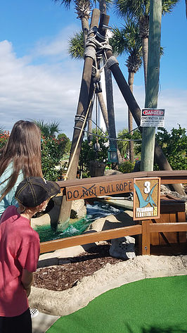miniature golf course at Wild Willys Dino Adventure with children looking at sign