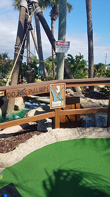 miniature golf course at Wild Willys Dino Adventure with sign saying to pull rope