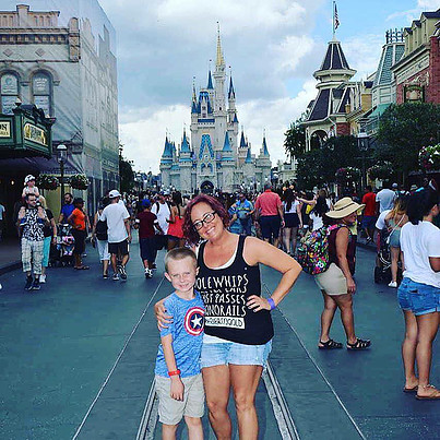 mother and son posing in front of Disney castle