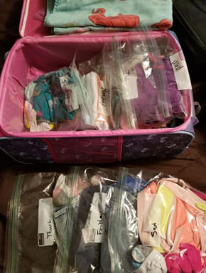 open suitcase with clothes in ziploc bags