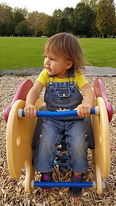 toddler playing on bouncy equipment at playground