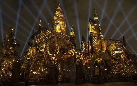 view of Hogwarts castle illuminated at night with yellow lights